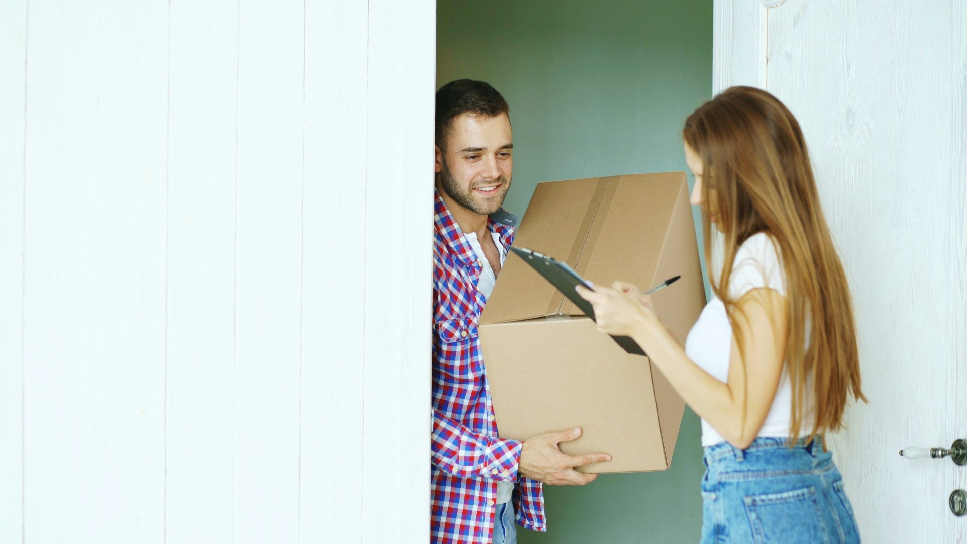 Paar unterschreibt an der Tür für die Zustellung eines Pakets